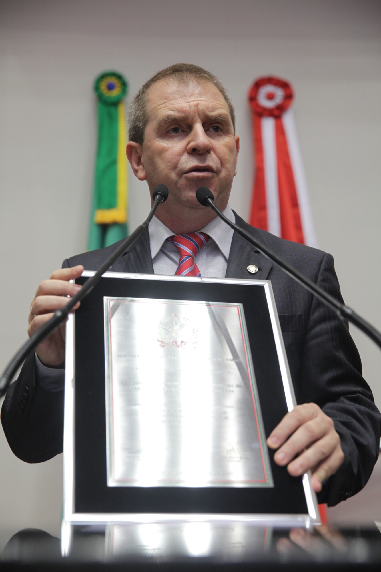 Deputado Mauricio Eskudlark mostra placa comemorativa que será entregue à direção do Sicoob – Credimoc. Foto: Lucas Gabriel Diniz