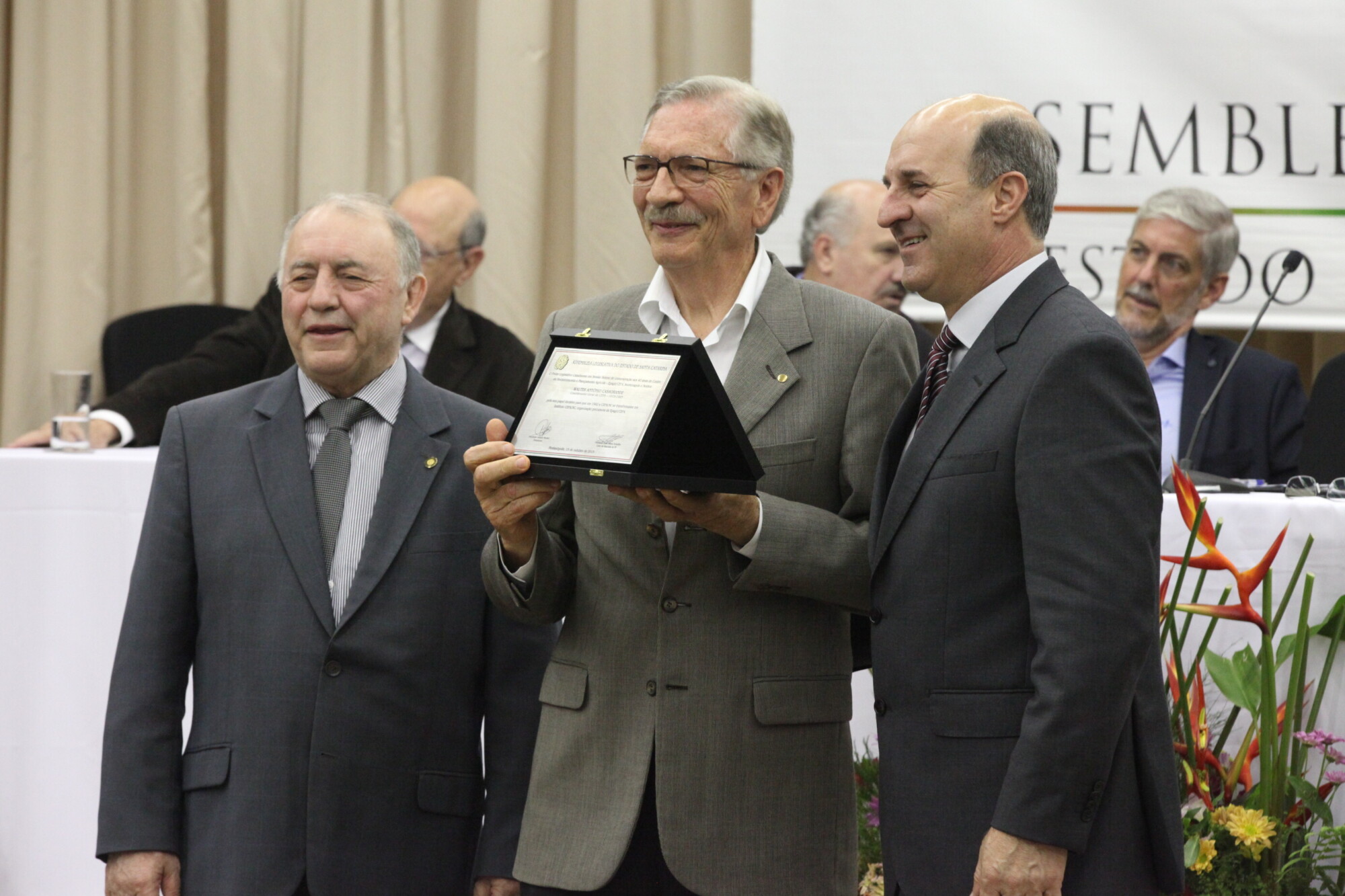 Walter Casagrande, ex-coordenador do Cepa, recebe placa dos deputados Natalino Lázare (e) e José Milton Scheffer. FOTO: Fábio Queiroz/Agência AL