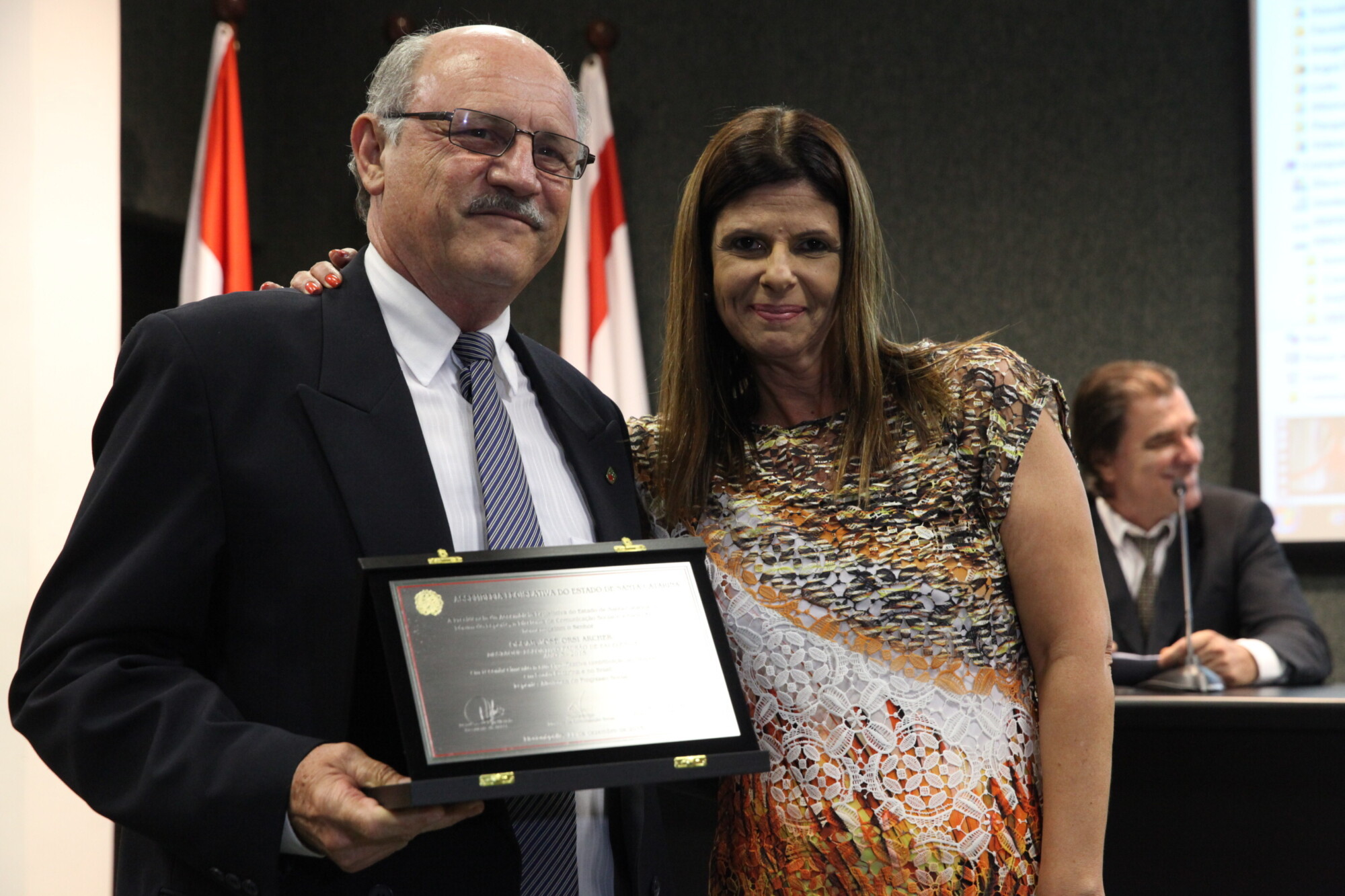 Claudia Alves entrega placa a Oscar Archer