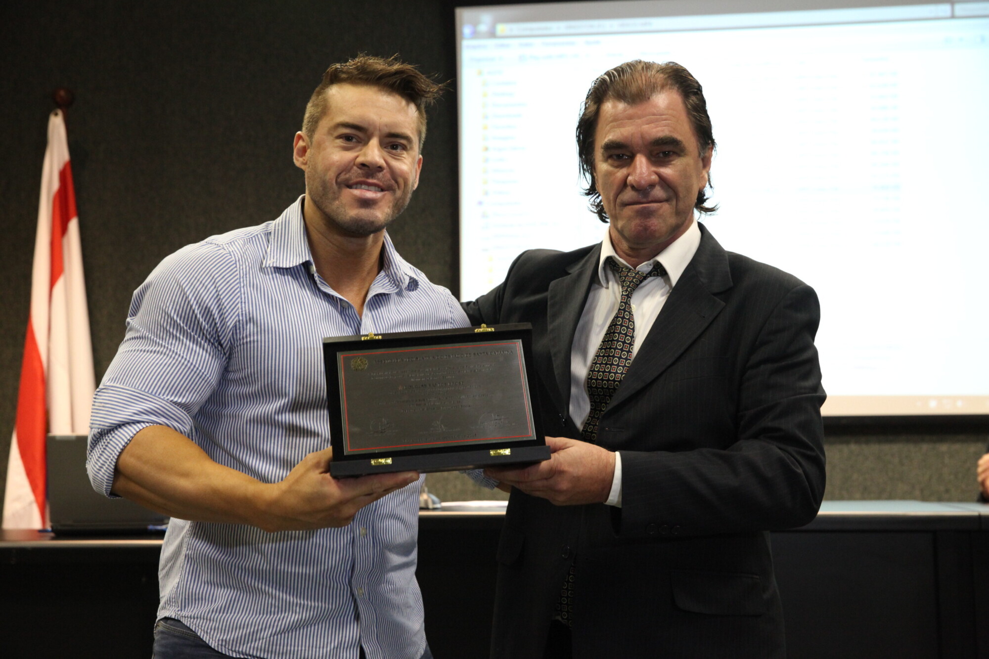 Eduardo Rocha (D) entrega placa a representante do atleta Douglas Brose