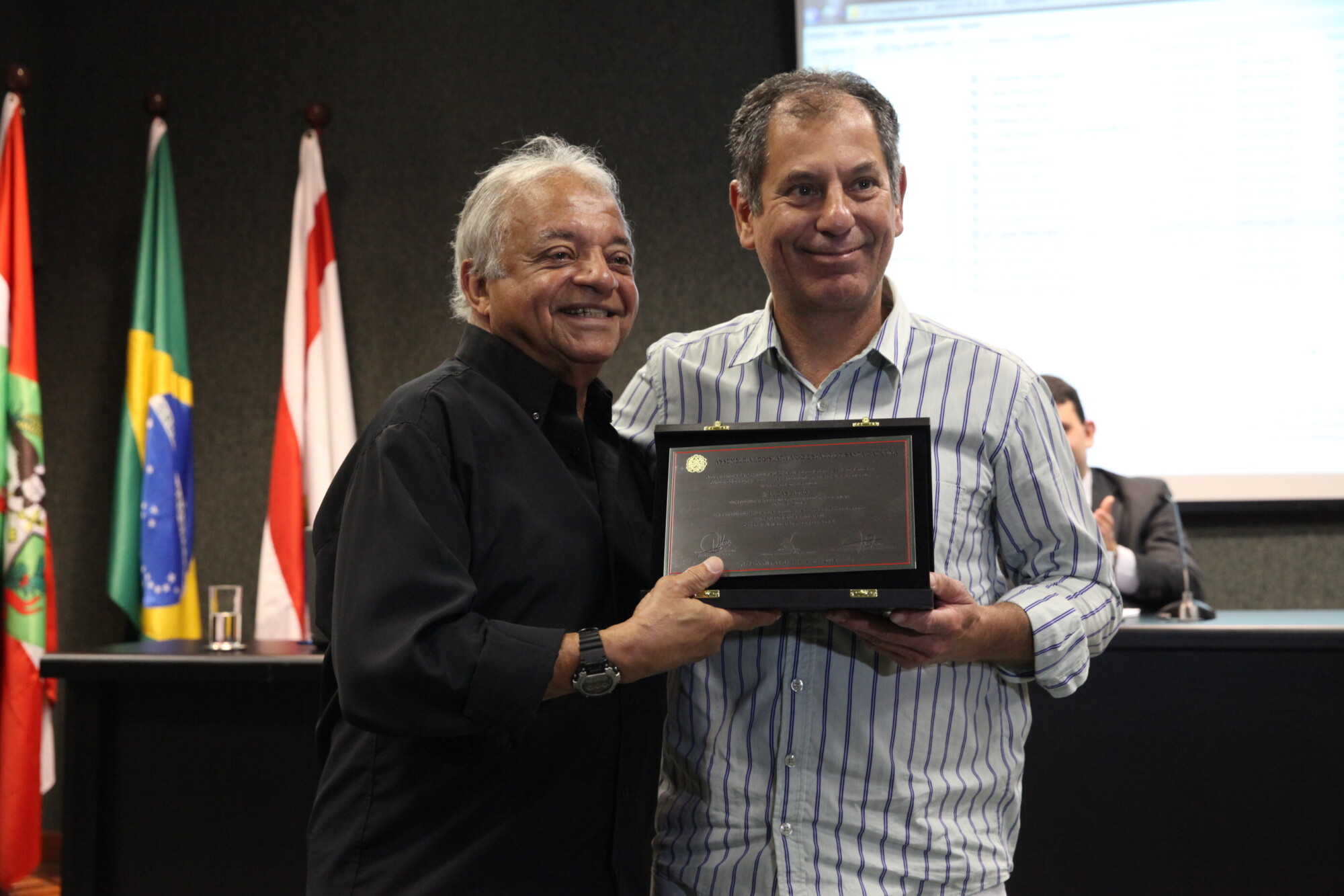 Hesio Dutra (E) entrega placa a representante do atleta Lucas Piero