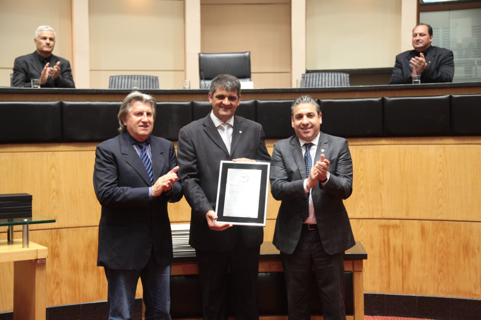 Presidente da FCM, Marisérgio Francisco Kons, recebe placa dos deputados Leonel Pavan e Mário Marcondes