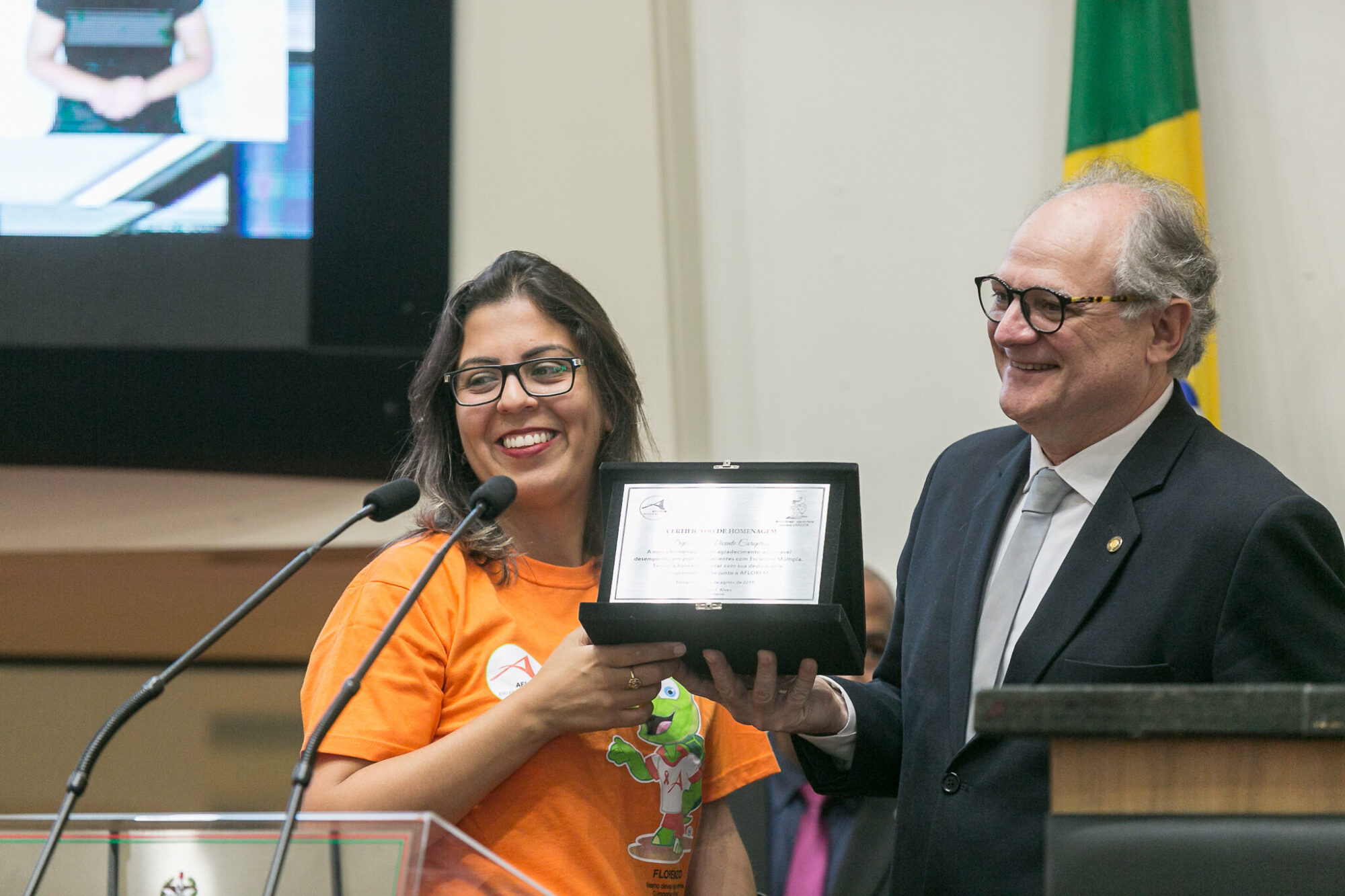 Suelen entrega placa ao deputado Dr. Vicente Caropreso (PSDB), que preside a preside a Comissão de Defesa dos Direitos das Pessoas com Deficiência.