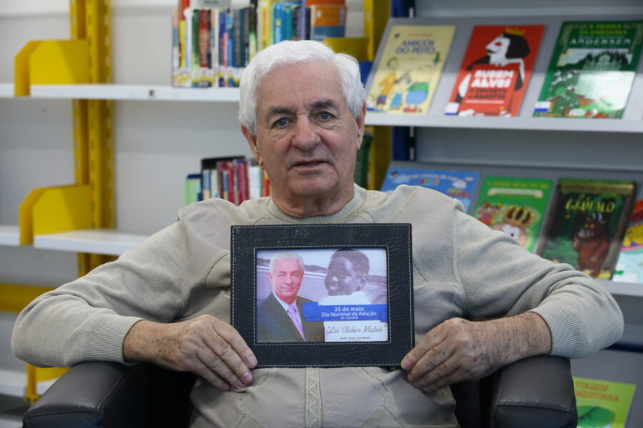 O ex-deputado federal e estadual João Matos, autor do projeto que resultou na Lei Nacional da Adoção; nas mãos dele, a imagem de Cleber, filho adotivo que dá nome à lei