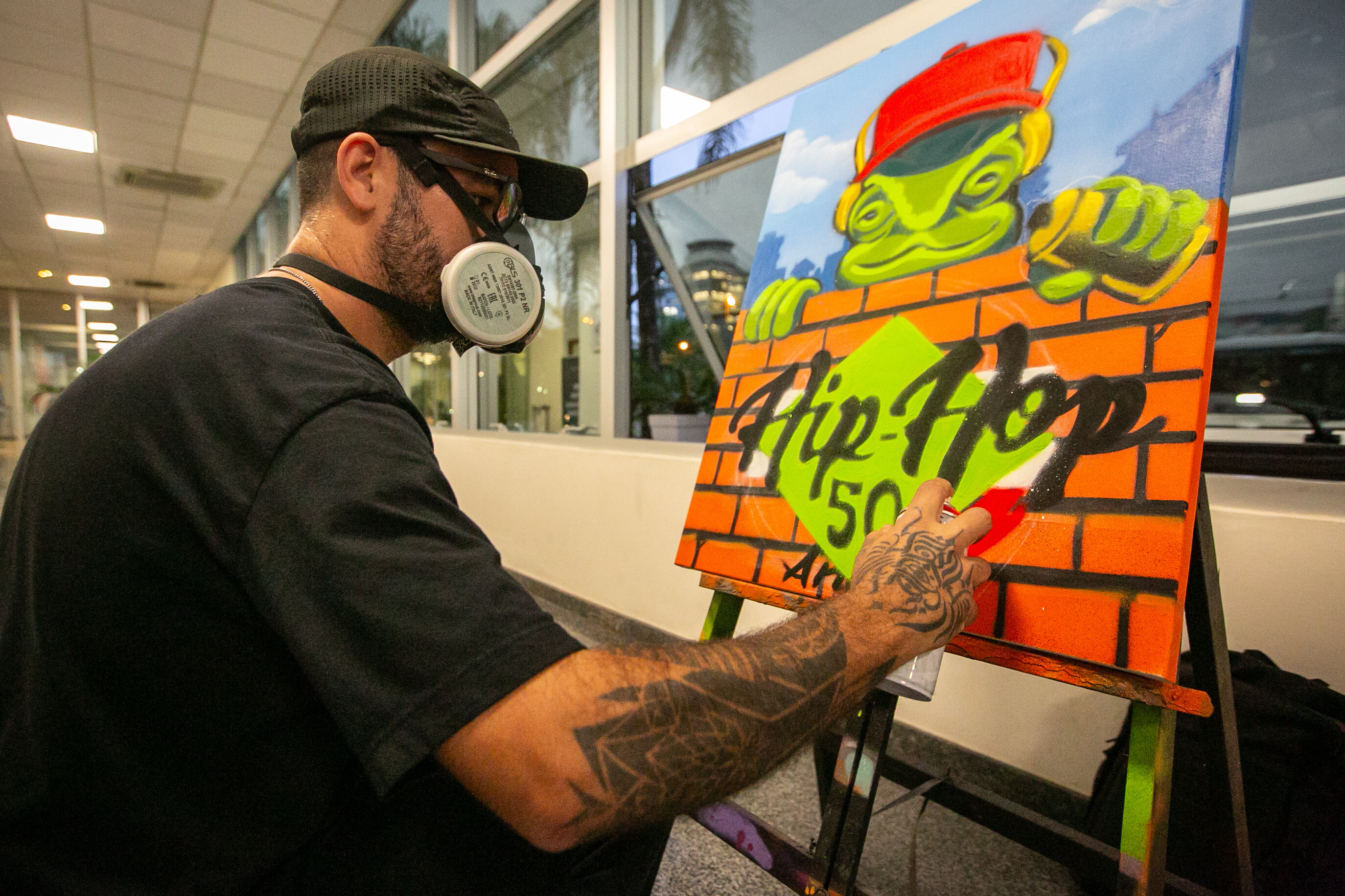 Grafiteiro Rodrigo Rizo produz uma tela durante o evento.