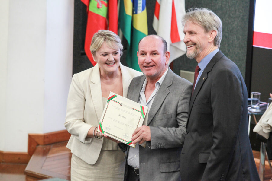 Deputados Luciane Carminatti e Pedro Uczai entregam placa a homenageado.