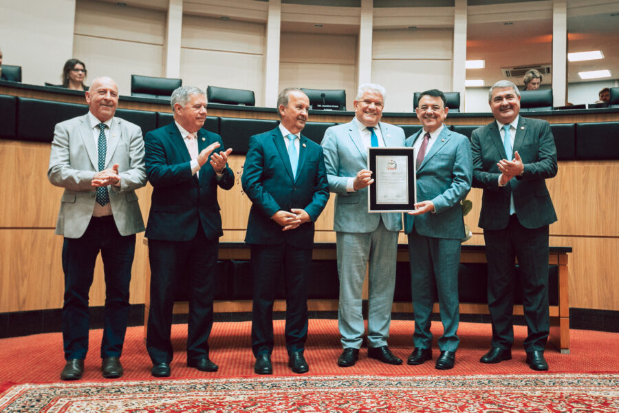 Ari Rabaiolli, presidente do Badesc, recebe placa comemorativa do deputado Maurício Peixer.