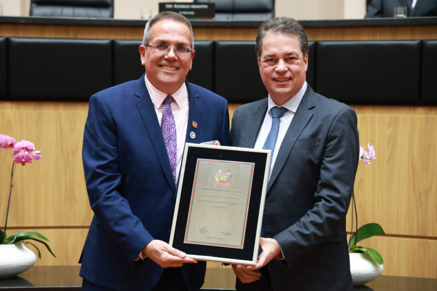 O presidente da Acesc, Polidoro Junior, recebe homenagem do deputado Rodrigo Minotto